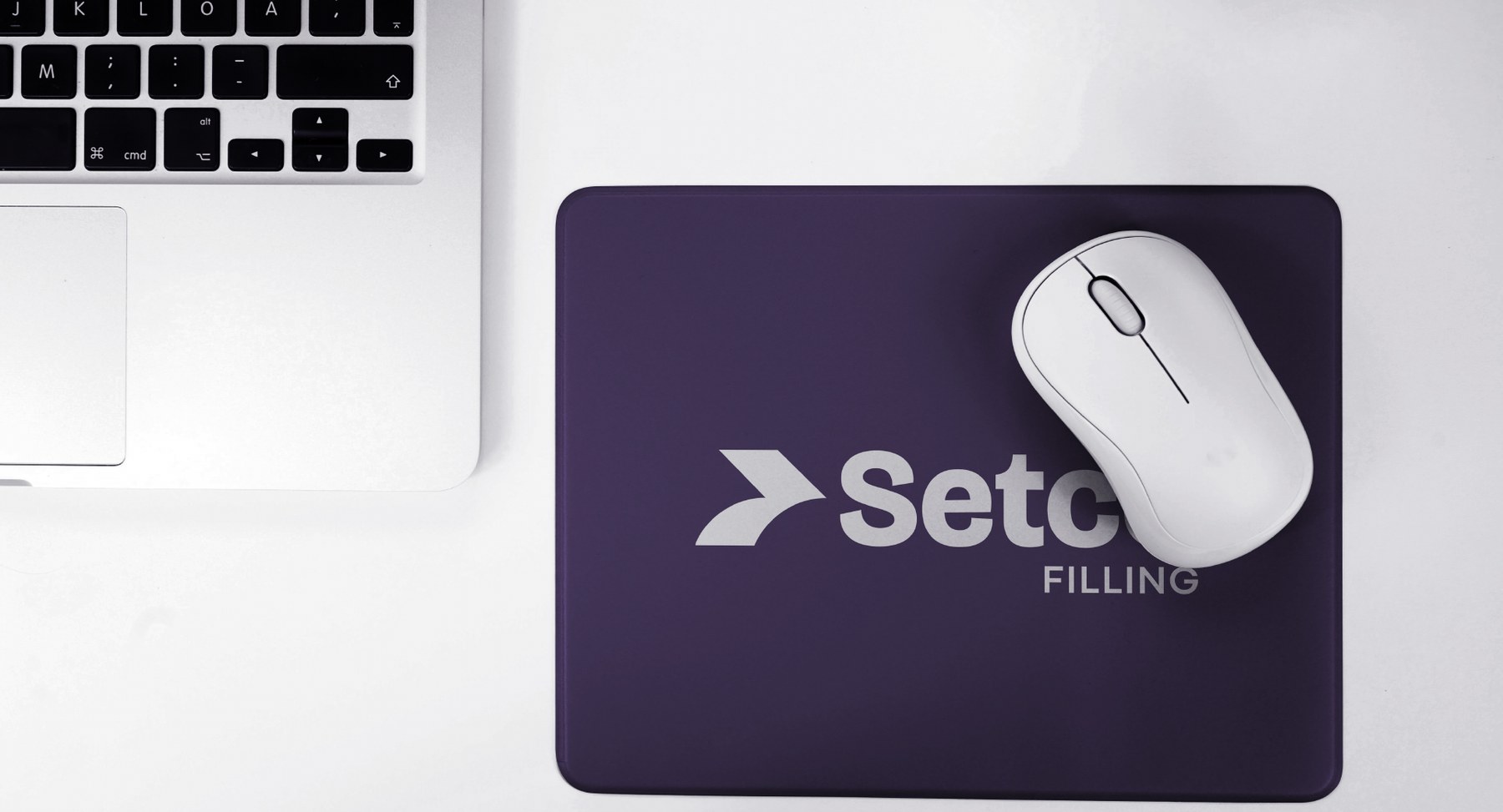 Branded mousepad on a desk beside a laptop